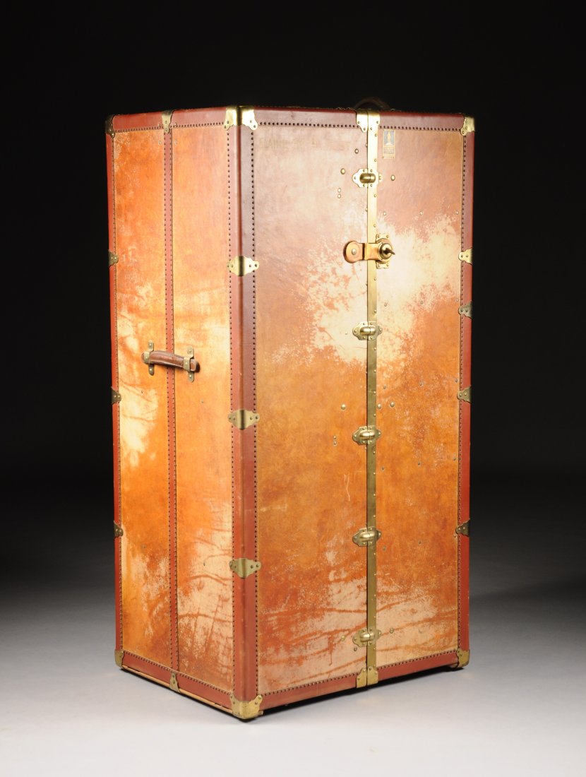 A LARGE AMERICAN LEATHER BOUND STEAMER TRUNK WITH BRASS: A LARGE AMERICAN LEATHER BOUND STEAMER TRUNK WITH BRASS HINGES AND BRACKETS, EARLY 20TH CENTURY, the interior revealing six drawers to one side, two sizes of hangers on a rod with extension and attach