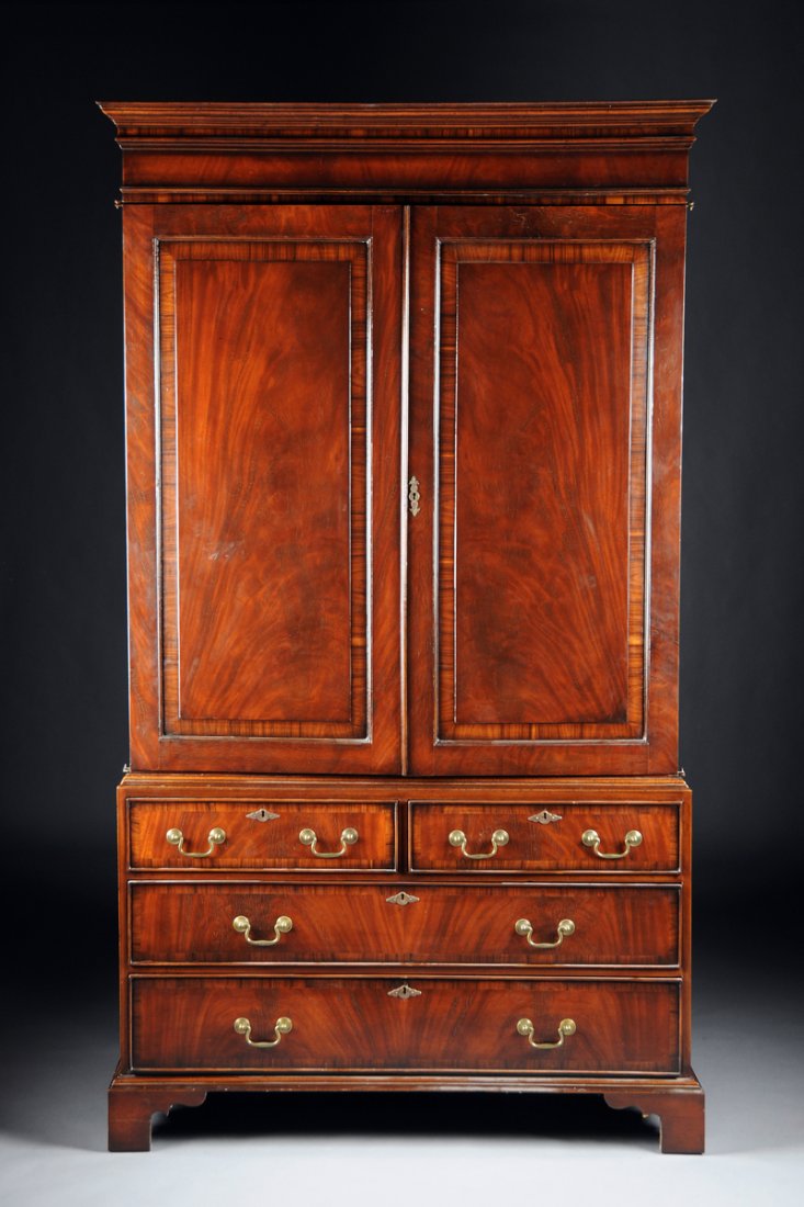 A GEORGE III STYLE KINGWOOD CROSS-BANDED MAHOGANY LINEN: A GEORGE III STYLE KINGWOOD CROSS-BANDED MAHOGANY LINEN PRESS, EARLY 20TH CENTURY, the rectangular molded cornice above a plain frieze and paneled doors opening to an adjustable shelf interior over gr
