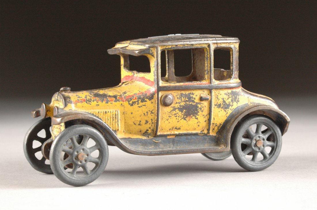 AN ARCADE CAST-IRON FORD COUPÉ ,: AN ARCADE CAST-IRON FORD COUPÉ , with original paint, missing driver. Paint loss, crack on top. Height: 3 1/2" Width: 7"