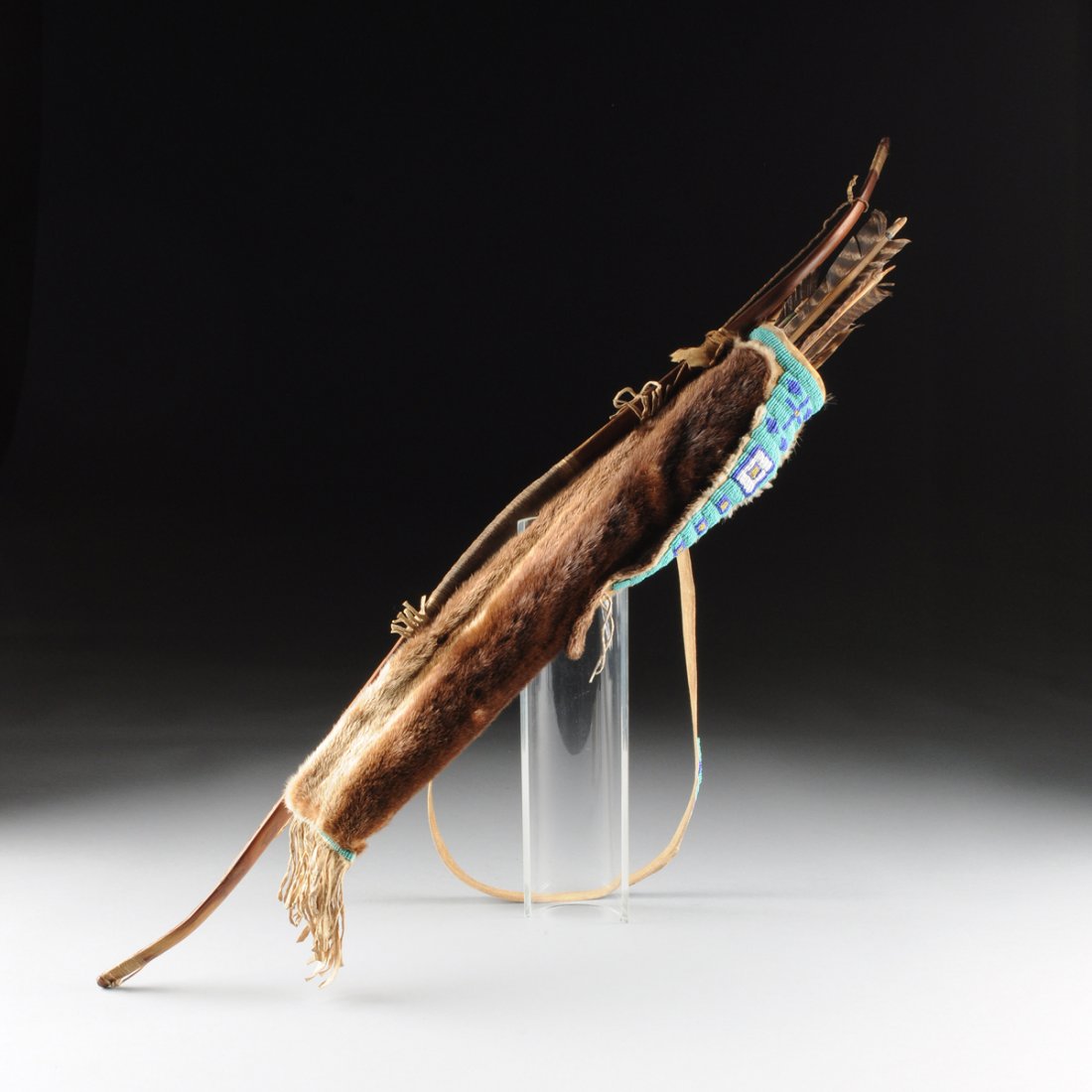 A NATIVE AMERICAN HAND CARVED OAK BOW WITH BEADED: A NATIVE AMERICAN HAND CARVED OAK BOW WITH BEADED BEAVER QUIVER AND SIX FLETCHED FEATHER ARROWS, 20TH CENTURY, the carved oak bow with string wrapped grip and ends, bowstring, with attached beaver fur