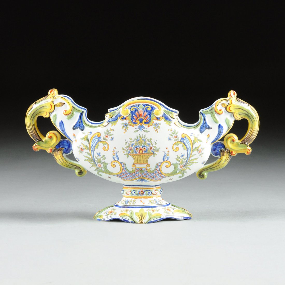 A FRENCH VEUVE BARES POLYCHROME PAINTED TWO-HANDLED: A FRENCH VEUVE BARES POLYCHROME PAINTED TWO-HANDLED FAIENCE CENTERPIECE, UNDERGLAZE BLUE MARK VVE BARES CLERMONT FD, LATE 19TH CENTURY, the centerpiece of flattened tapered oval form with scalloped ri
