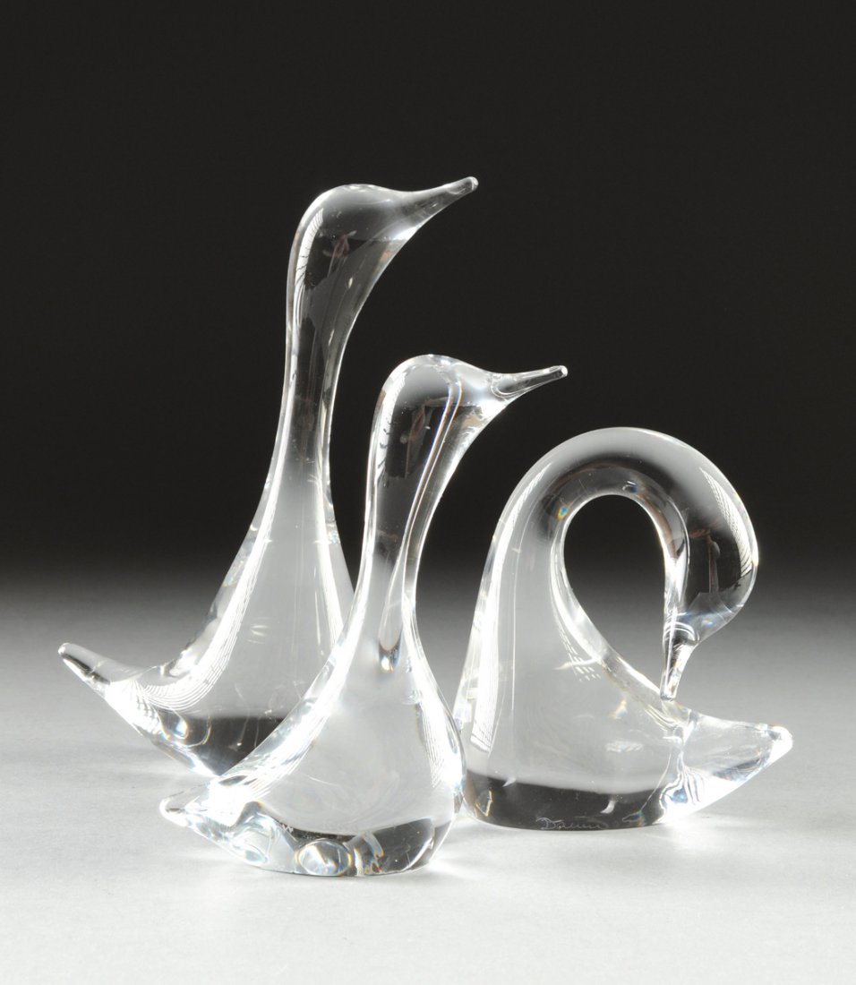 A GROUP OF THREE DAUM CLEAR CRYSTAL FIGURES, NANCY,: A GROUP OF THREE DAUM CLEAR CRYSTAL FIGURES, NANCY, FRANCE, 20TH CENTURY, comprising a large upright goose, height: 8"; a smaller upright goose, height: 5 3/4"; both with engraved mark Daum France; an