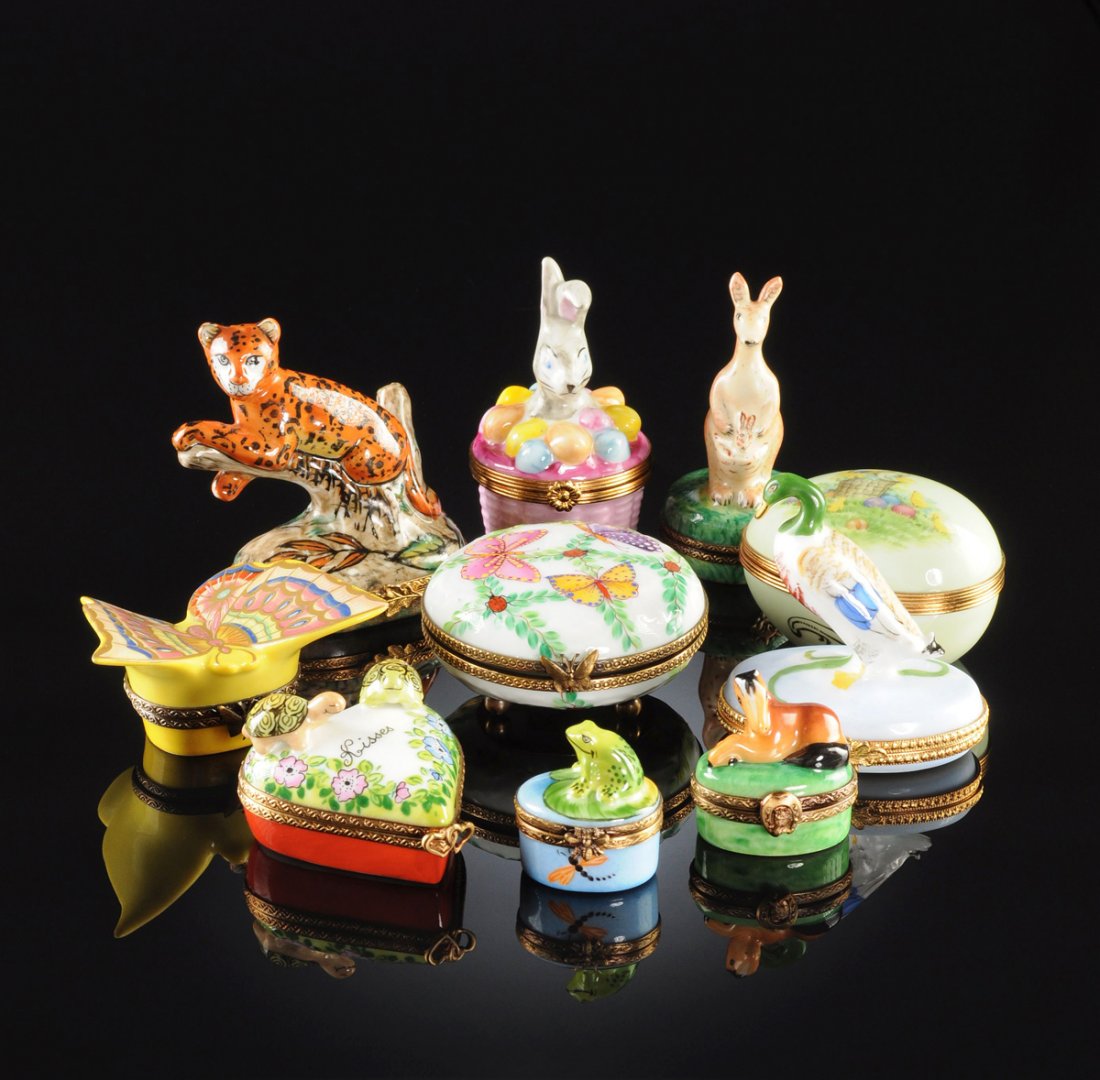 A GROUP OF TEN LIMOGES PORCELAIN FIGURAL PILL BOXES,: A GROUP OF TEN LIMOGES PORCELAIN FIGURAL PILL BOXES, 20TH CENTURY, comprising an egg form box with transfer printed Easter theme decoration and gilt metal rim by Artoria; a heart shaped box with two a