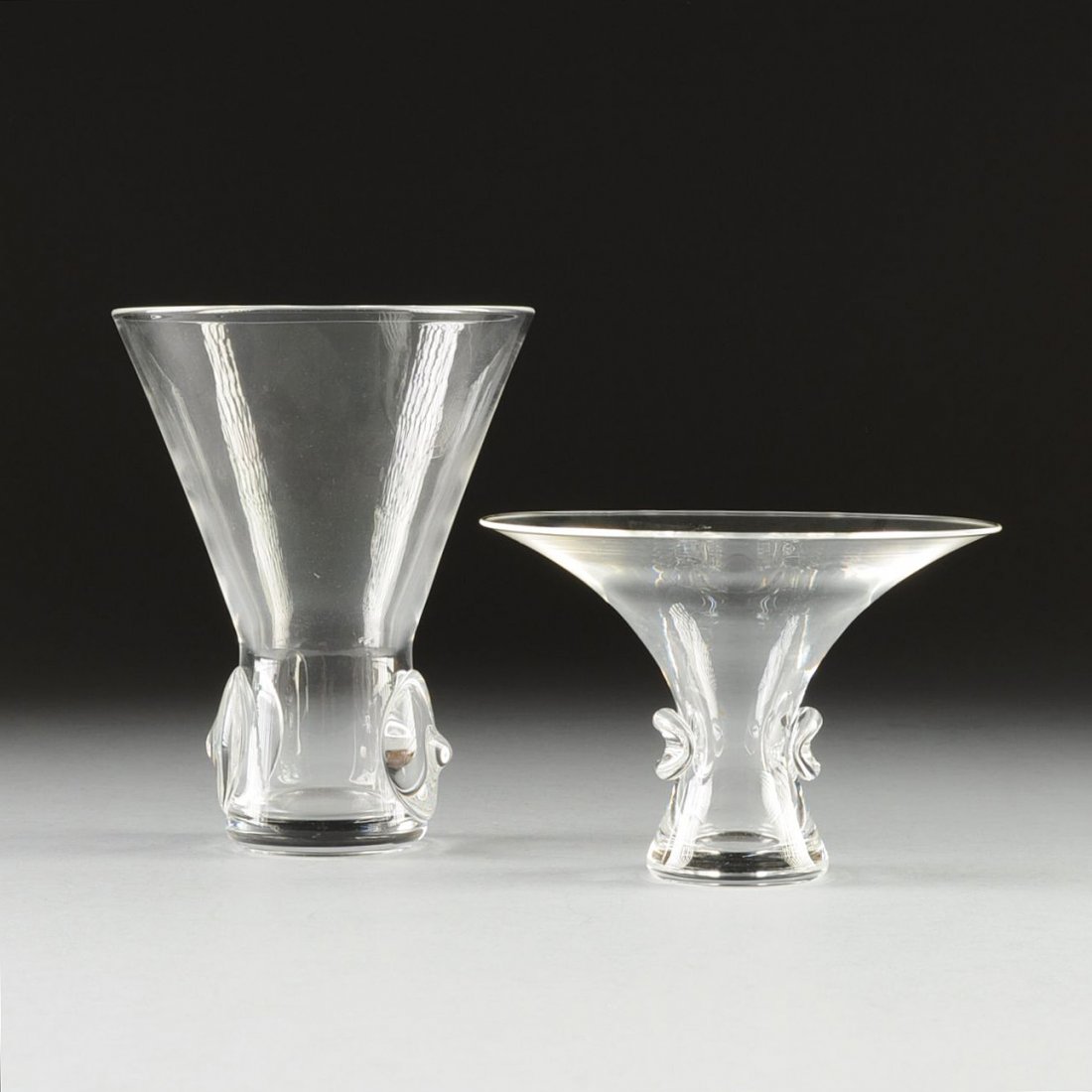 TWO STEUBEN CRYSTAL VASES, DESIGNED BY GEORGE THOMPSON,: TWO STEUBEN CRYSTAL VASES, DESIGNED BY GEORGE THOMPSON, BOUQUET 7985 AND FLARING 8069 PATTERNS, ENGRAVED SIGNATURE, THIRD QUARTER 20TH CENTURY, each of flaring form and base sides centering applied ci