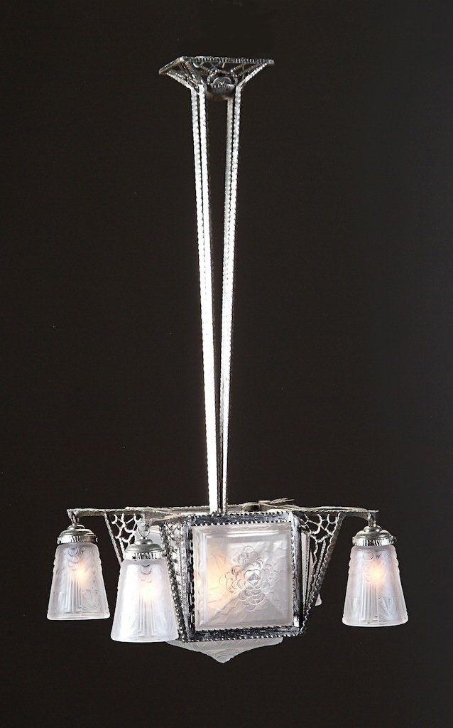 A FRENCH ART DECO PERIOD NICKEL PLATED HAMMERED METAL: A FRENCH ART DECO PERIOD NICKEL PLATED HAMMERED METAL AND FROSTED GLASS CHANDELIER, the square central shade comprising five panels surrounded by four pendant shades designed by Muller Frères Lunevil