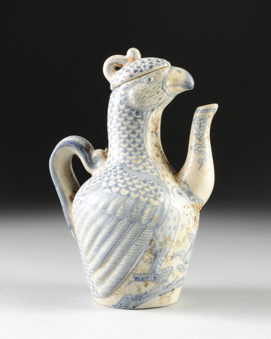 A VIETNAMESE/ANNAMESE BLUE AND WHITE CERAMIC BIRD FORM: A VIETNAMESE/ANNAMESE BLUE AND WHITE CERAMIC BIRD FORM EWER, 15TH/16TH CENTURY, painted with underglaze blue details throughout and modeled with a short beak and idealized features incorporating a con
