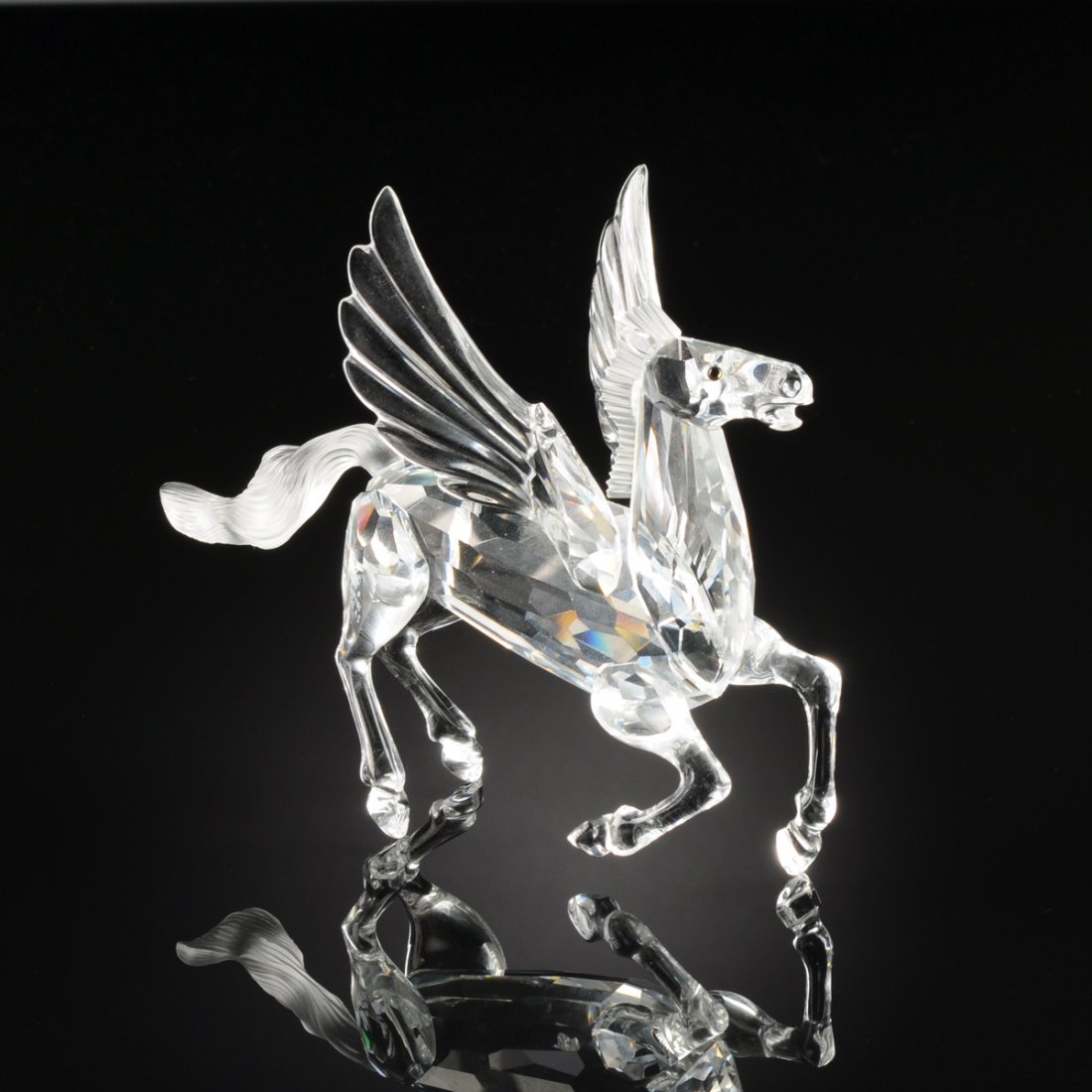 A SWARVOSKI CLEAR CRYSTAL FIGURE OF "PEGASUS," DESIGNED: A SWARVOSKI CLEAR CRYSTAL FIGURE OF "PEGASUS," DESIGNED BY ADI STOCKER, WATTENS, AUSTRIA, 1998, with dark brown crystal eyes and frosted mane and tail, acid etched marks: (swan), "SWARVOSKI, 98 AS," t