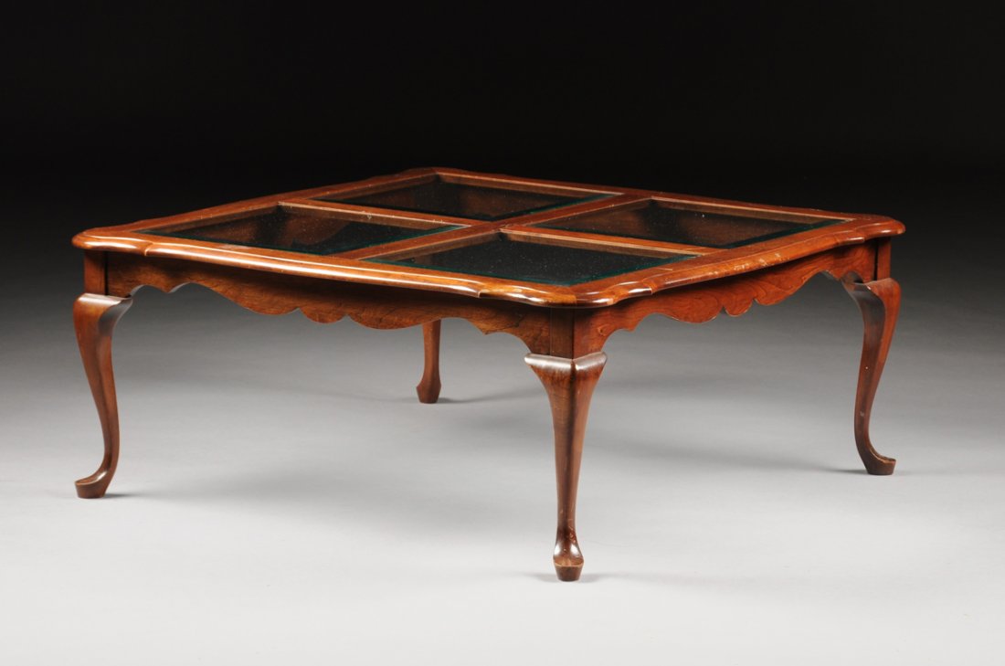 A QUEEN ANNE REVIVAL STYLE CARVED MAHOGANY AND BEVELED: A QUEEN ANNE REVIVAL STYLE CARVED MAHOGANY AND BEVELED GLASS OCCASIONAL TABLE, 20TH CENTURY, the shaped rectangular top enclosing square glass panels above a shaped frieze, raised on cabriole legs end