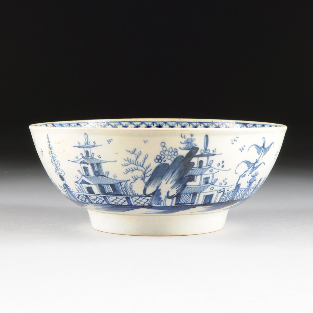 A LIVERPOOL PEARLWARE BOWL WITH HAND PAINTED: A LIVERPOOL PEARLWARE BOWL WITH HAND PAINTED CHINOISERIE DECORATION, ENGLAND, CIRCA 1775, hand painted with stylized pagoda, garden fence, and tree decoration in underglaze blue, the interior decorate