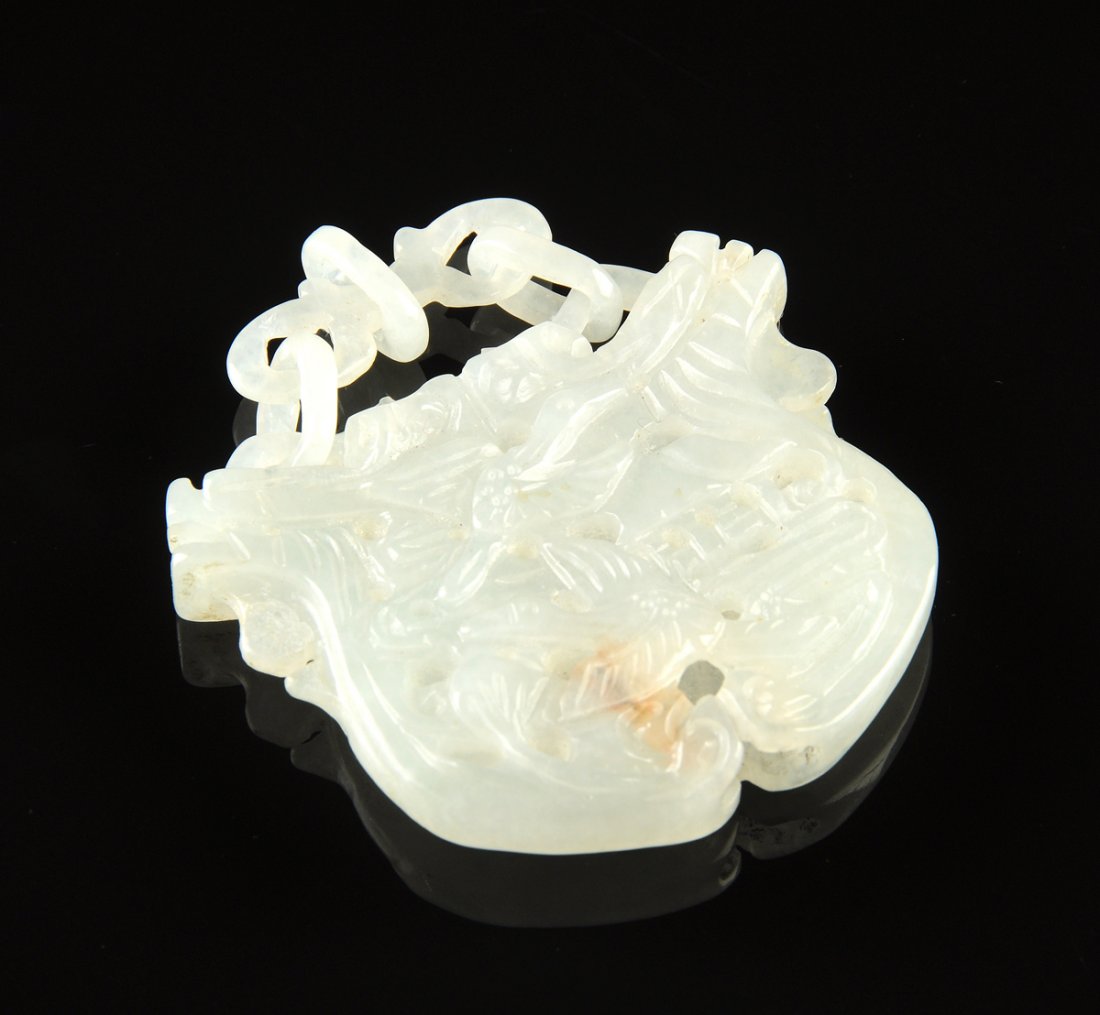 A CHINESE CARVED PALE GREEN JADE PENDANT WITH LOOSE: A CHINESE CARVED PALE GREEN JADE PENDANT WITH LOOSE RINGS, 20TH CENTURY, of a pale green even tone with slight russet inclusions, good translucency, one side carved with monkeys over a peach, the othe