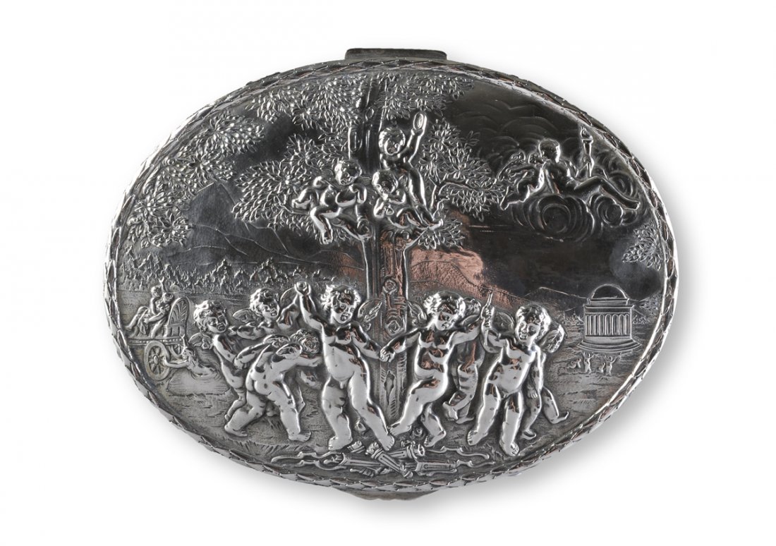 A GERMAN SILVER REPOUSSÉ HINGED BOX, EARLY 20TH: A GERMAN SILVER REPOUSSÉ HINGED BOX, EARLY 20TH CENTURY, of oval shape and depicting cherubs frolicking around a large tree set amidst a classical garden within laurel detailed trim above sides of sc