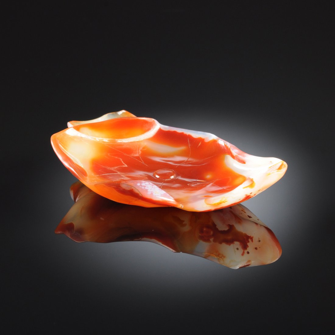 A CHINESE CARVED STRIPED AGATE BRUSH WASHER, MODERN: A CHINESE CARVED STRIPED AGATE BRUSH WASHER, MODERN realistically detailed as a lotus pod and leaf in shades of burnt umber contrasting opaque white. Height: 7/8" Width: 4 1/2" Depth: 2 7/8"