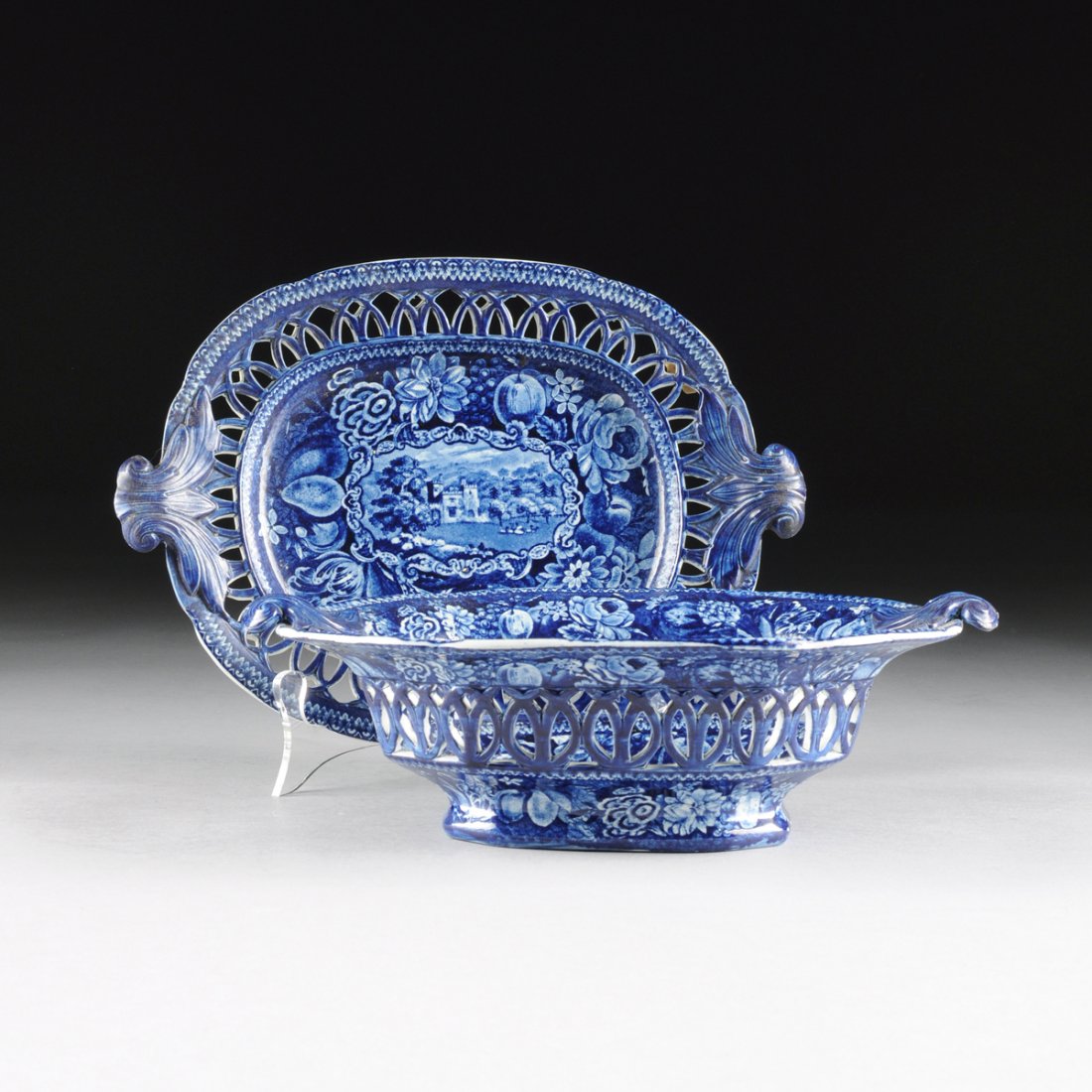 A RALPH HALL BLUE AND WHITE TRANSFER PRINT STONE CHINA: A RALPH HALL BLUE AND WHITE TRANSFER PRINT STONE CHINA RETICULATED BASKET AND STAND FROM THE "SELECT VIEWS" SERIES, TUNSTALL, STAFFORDSHIRE, ENGLAND, CIRCA 1822-1836, shaped oval with reticulated side