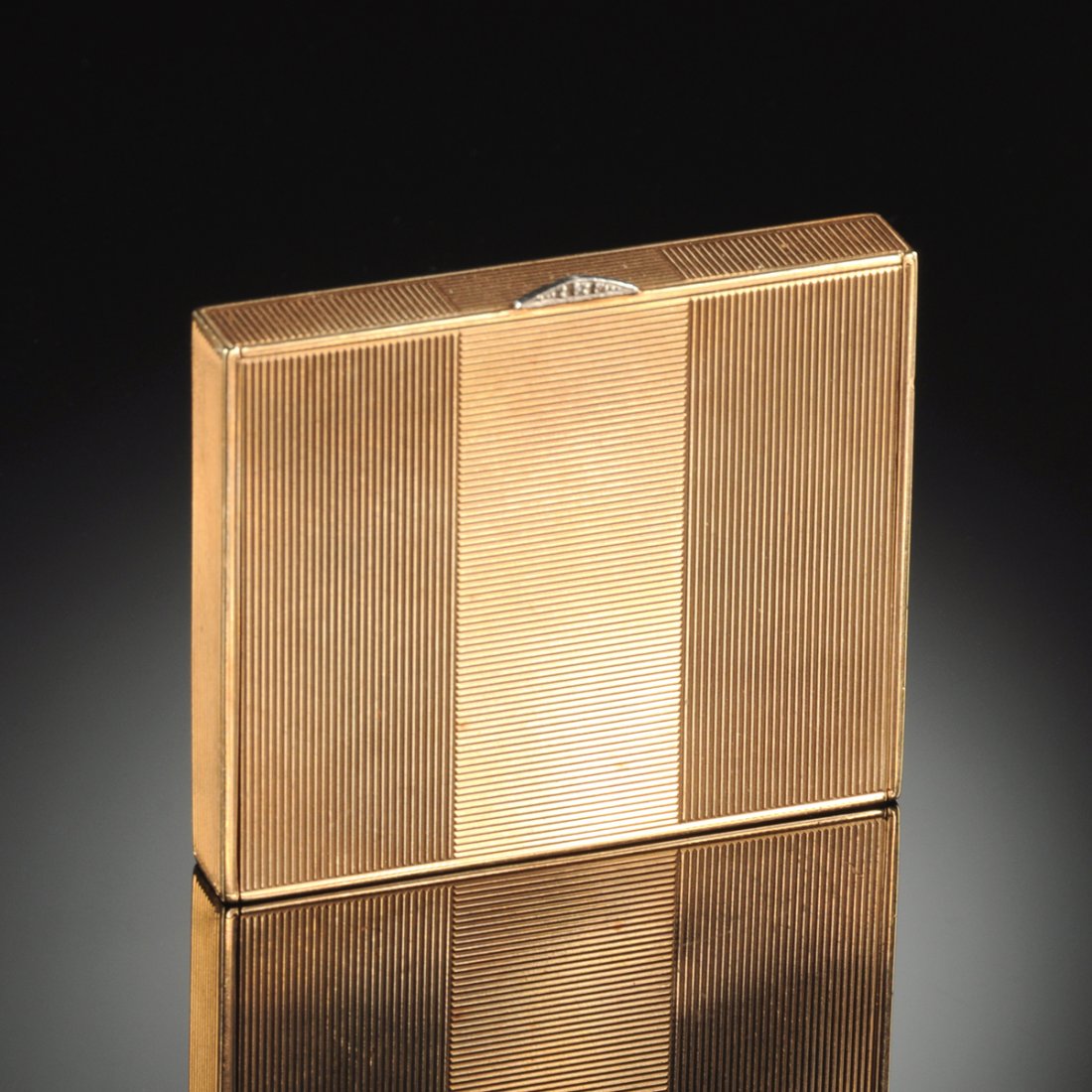 A 14K ROSE GOLD LADY'S POWDER BOX, : A 14K ROSE GOLD LADY'S POWDER BOX, with ribbed chased sides, base, and lid opening to a mirrored face powder compartment. Accented with three diamonds.