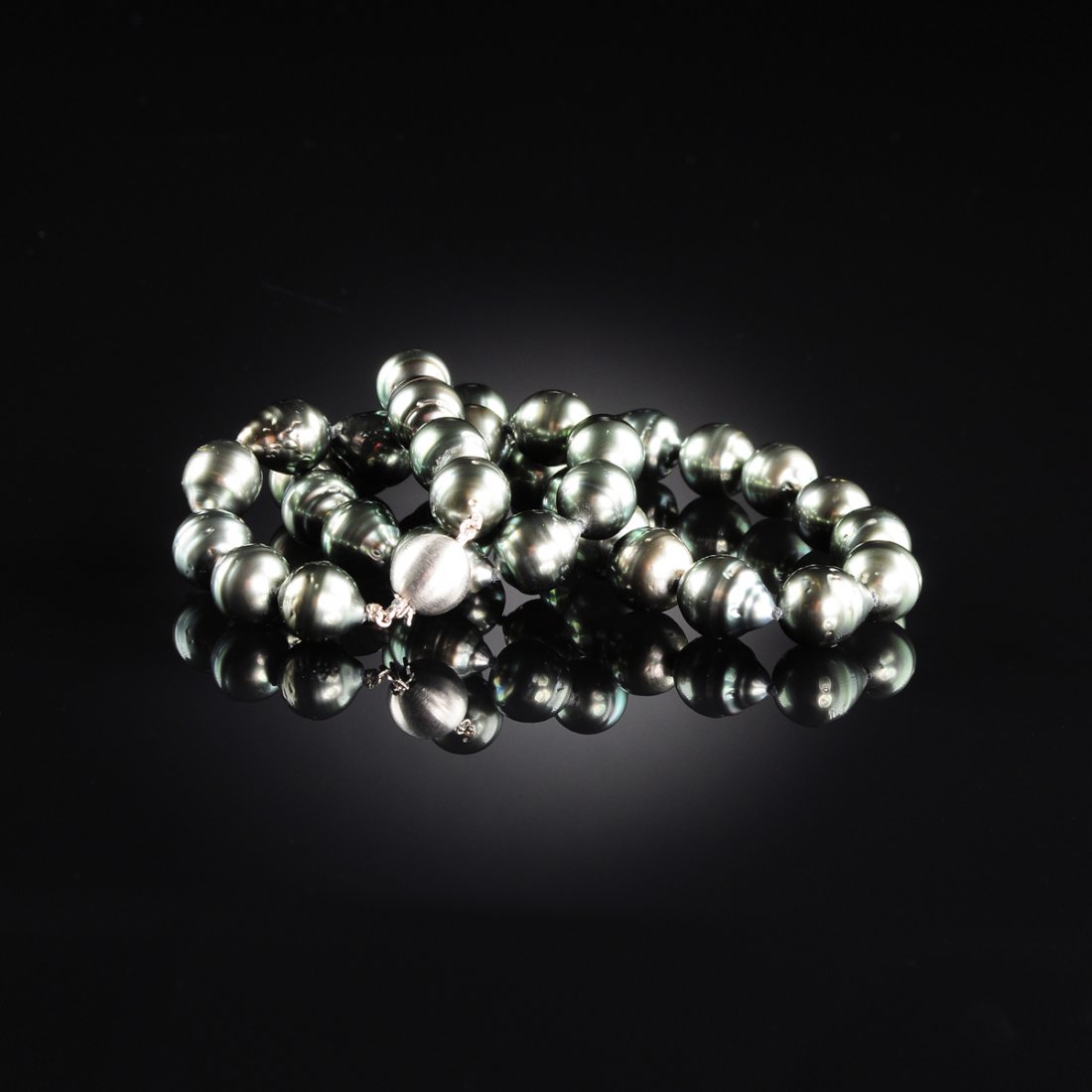 A STRAND OF TAHITIAN SOUTH SEA PEARLS,: A STRAND OF TAHITIAN SOUTH SEA PEARLS, the thirty-six graduated gray pearls ranging in size from 10 millimeters to 11.1 millimeters. Length approximately 18" overall.