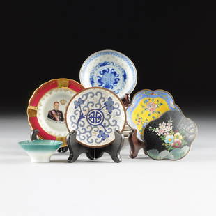 A GROUP OF ELEVEN CHINESE ASSORTED PORCELAIN AND: A GROUP OF ELEVEN CHINESE ASSORTED PORCELAIN AND ENAMELED METAL WARES, 20TH CENTURY, comprising a set of seven small white metal wrapped blue and white porcelain dishes centering various shou