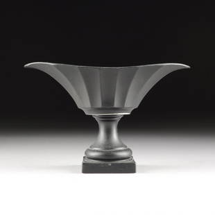 A NEOCLASSICAL STYLE BLACK PAINTED CERAMIC CENTERPIECE: A NEOCLASSICAL STYLE BLACK PAINTED CERAMIC CENTERPIECE BOWL, MODERN, of oval form and fluted flaring sides, raised on a circular socle and square plinth. Height: 7 1/2" Width: 13 3/8" Depth: 6 1/2"