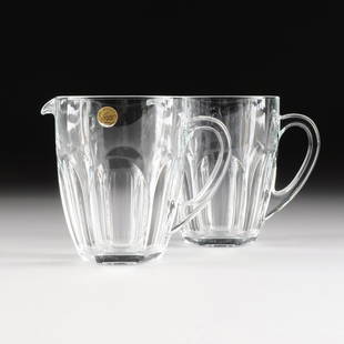A PAIR OF FRENCH MOLDED AND CUT CRYSTAL PITCHERS, BY: A PAIR OF FRENCH MOLDED AND CUT CRYSTAL PITCHERS, BY CRISTAL D'ARQUES, MODERN, each of tapering circular form and arched concave decoration flanked by small everted spout opposite a loop handle, one