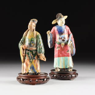 TWO CHINESE POLYCHROME GLAZED EARTHENWARE DEITIES,: TWO CHINESE POLYCHROME GLAZED EARTHENWARE DEITIES, EARLY 20TH CENTURY, one wearing a scholars cap above plum colored long robes centering a square form rank badge, on a circular reticulated carved