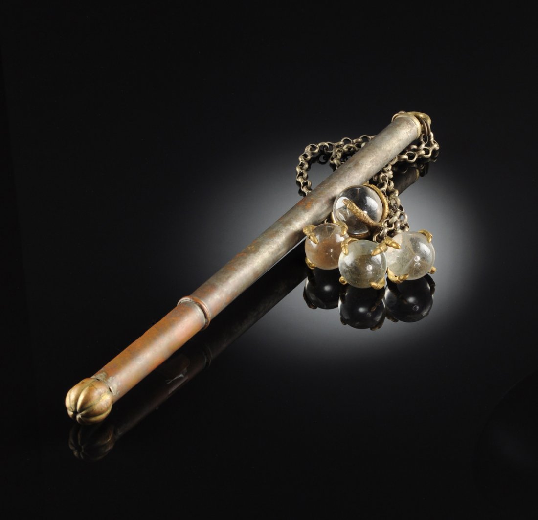 A VINTAGE SILVERED METAL AND CHAINED GLASS BALL FLAIL,: A VINTAGE SILVERED METAL AND CHAINED GLASS BALL FLAIL, 20TH CENTURY, the cylindrical rod form handle ending in a brass melon form lobed sphere opposite a brass loop cap suspending four chains ending i