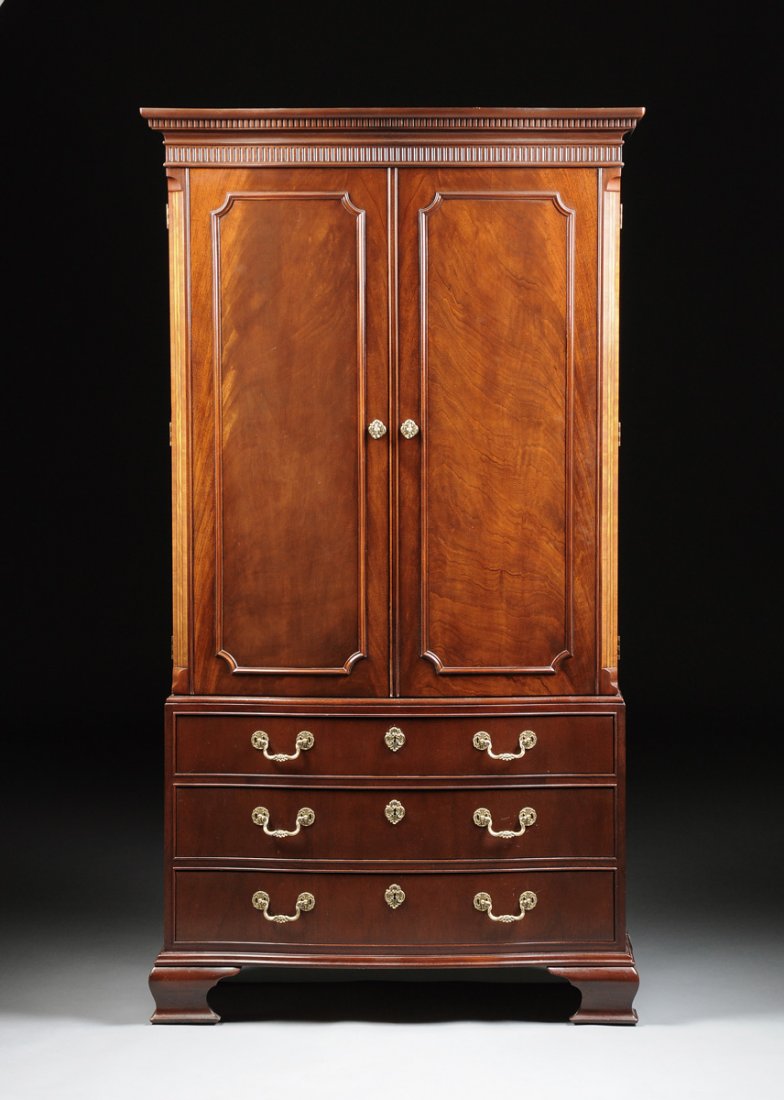 A GEORGE III STYLE BOW FRONT MAHOGANY CABINET, BY BAKER: A GEORGE III STYLE BOW FRONT MAHOGANY CABINET, BY BAKER FURNITURE, MODERN, the bow front rectangular body with a dentilated cornice over a similarly detailed frieze and two paneled doors, opening to a