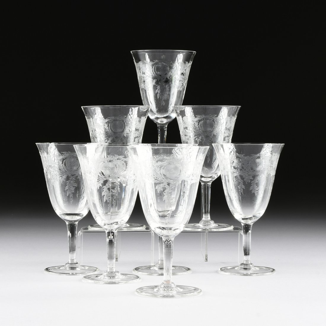 A SET OF EIGHT CRYSTAL WINE GLASSES, 20TH CENTURY,: A SET OF EIGHT CRYSTAL WINE GLASSES, 20TH CENTURY, with a low relief incised scrolling foliage detail, on tapering circular stem with a conforming base. No maker's mark. Height: 6 1/2"