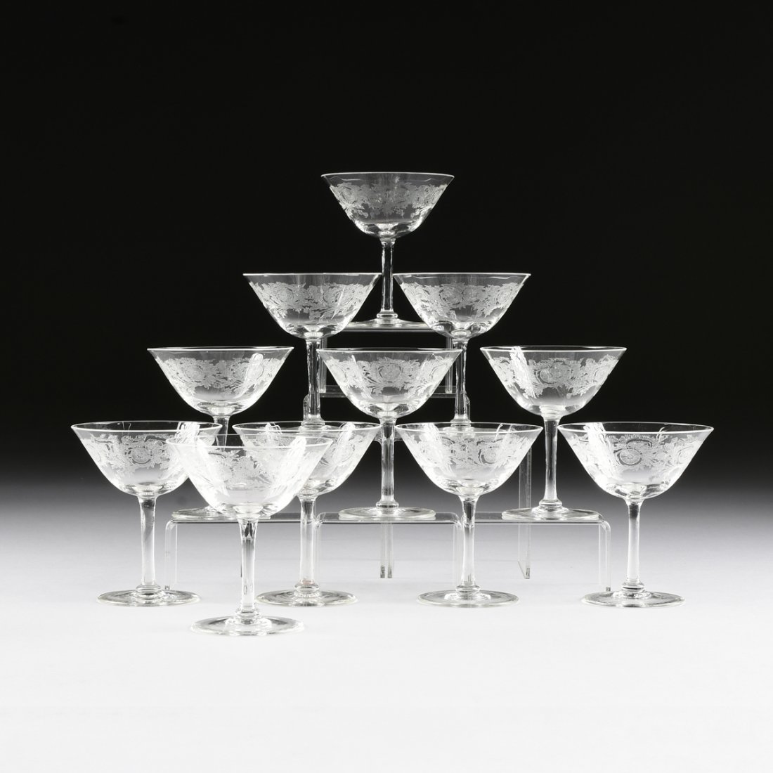 A SET OF ELEVEN CRYSTAL CHAMPAGNE COUPES, 20TH CENTURY,: A SET OF ELEVEN CRYSTAL CHAMPAGNE COUPES, 20TH CENTURY, with a low relief incised scrolling foliage detail, on tapering circular stem with a conforming base. No maker's mark. Height: 4 1/2"