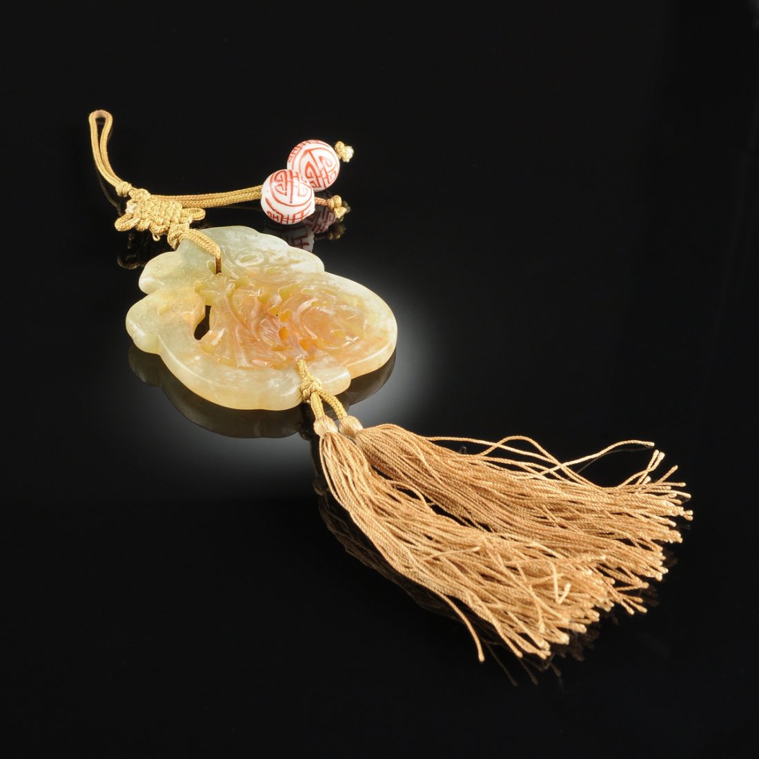 A CHINESE CELADON AND RUSSET BROWN CARVED JADE PENDANT, (1 of 3)