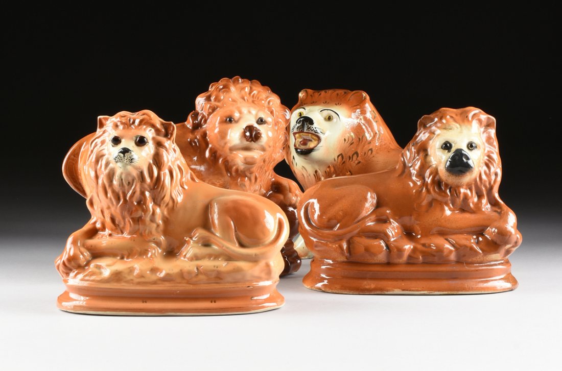 A GROUP OF FOUR ENGLISH STAFFORDSHIRE GLAZED: A GROUP OF FOUR ENGLISH STAFFORDSHIRE GLAZED EARTHENWARE LIONS, LATE 19TH/EARLY 20TH CENTURY, each with glass eyes and painted in tones of light brown, comprising one in a standing position and clear 