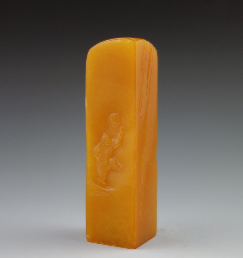 CHINESE TIANHUANG CRAVED SEAL: A rare finely carved Tianhuang stone seal stamp; one side depicting boy playing with fan, lotus design on the reverse side; bottom uncarved; crystal and moist texture; Tianhuang is regarded as the bes