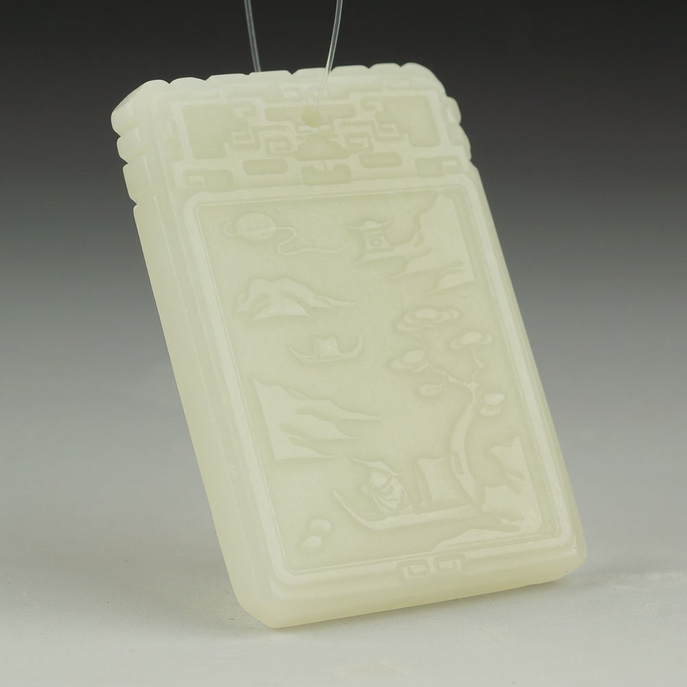 CHINESE XINJIANG CARVED NEPHRITE JADE PENDANT: Chinese Xinjiang rectangular nephrite jade pendant plaque; with low relief design of figure in a landscape to the front and calligraphy to the reverse; archaistic motif at the top. Size: 50 x 34 x 0.4