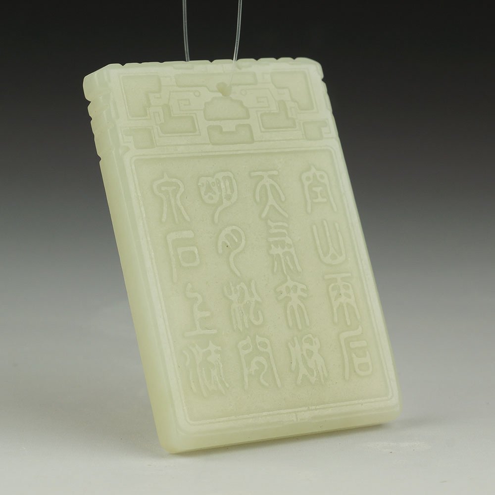 XINJIANG CARVED NEPHRITE JADE PENDANT: Chinese Xinjiang rectangular nephrite jade pendant plaque; with low relief design of figures in a landscape to the front and calligraphy to the reverse; archaistic motif at the top. Size: 60 x 30 x 0.
