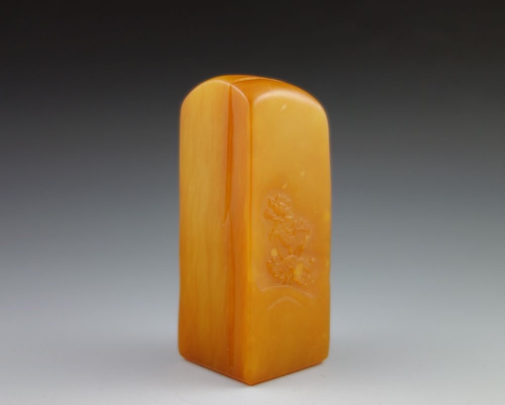 CHINESE TIANHUANG CRAVED SEAL: A rare finely carved Tianhuang stone seal stamp; one side depicting boy playing with fan, lotus design on the reverse side; bottom uncarved; crystal and moist texture; Tianhuang is regarded as the bes