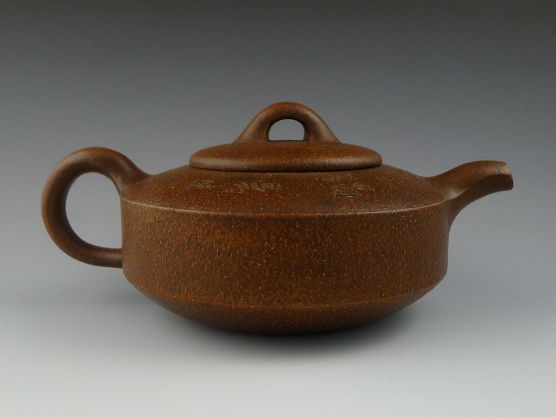 CHINESE YIXING CLAY TEAPOT: Chinese Yixing Clay Teapot with carved calligraphy, bottom holds four character calligraphy seal mark. Size: 6.5 x 4 x 4.5".