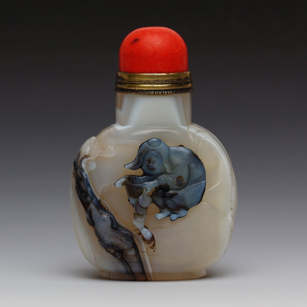 CHINESE CAMEO CARVED AGATE SNUFF BOTTLE: Chinese finely hollowed, cameo carved agate snuff bottle; of flattened circular form; the front with design of two horses and a cloud above in relief, ; good use of color; red coral-like stopper; H: 3