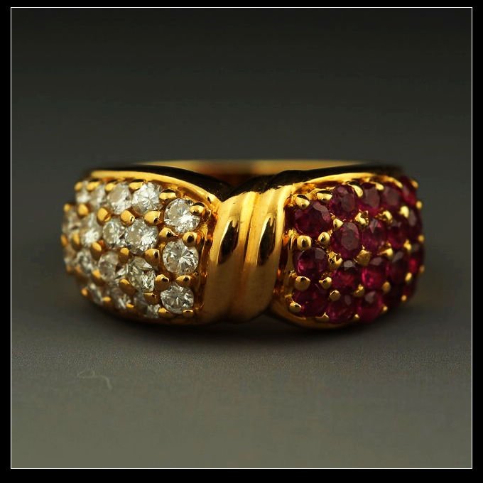 18K YELLOW GOLD, RUBY & DIAMOND RING: Large 18K yellow gold, ruby and diamond ring; of somewhat ribbon form and set with round cut diamonds and rubies on each side. Weight: 8.41 g