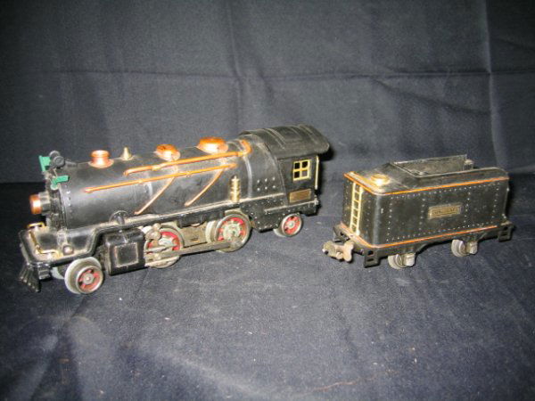 LIONEL STEAM ENGINE AND BLACK TENDER, NO. 261: LIONEL STEAM ENGINE 2-4-2 AND BLACK TENDER, NO. 261. "O" GAUGE. SOME WEAR ON FRONT. SMALL GREEN FLAGS ON FRONT. VGC. BLACK TENDER NO. 257 T ON BOTTOM. "O" GAUGE. SOME RUSTING.