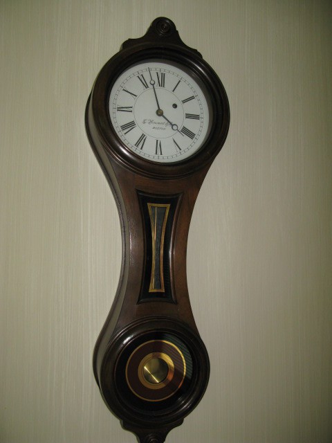 "FIGURE EIGHT" CLOCK BY E. HOWARD & CO.: "FIGURE EIGHT" CLOCK, RED, BLACK & GOLD-LEAF GLASS IN BLACK WALNUT CASE, PENDULUM. THIS CLOCK HAD A LIMITED RE-ISSUE OF 1000 BY THE E. HOWARD AND CO. CLOCK CO., WALTHAM, MASS. THIS IS MODEL 10. THE "F