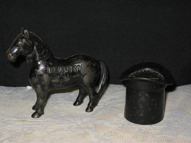 (2) STILL BANKS "BEAUTY" & "LINCOLN'S TOPHAT": (2) STILL BANKS. (1) "BEAUTY", HORSE BANK. WORN LACQUER, ARCADE US, CAST IRON, 1910-1932, APP. 4 1/4". (2) "LINCOLN'S TOPHAT", MARKED PASS AROUND THE HAT. MINOR PAINT WEAR. APP. 3".