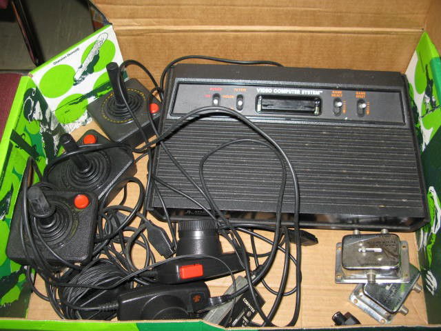 ATARI 2600 COMPLETE WITH 30 GAMES: ATARI 2600 COMPLETE WITH 30 GAMES. INCLUDES 3 JOYSTICKS, 2 DRIVING REMOTES AND MANUALS FOR GAMES. COMES WITH 30 GAMES: SPACE INVADERS, PITFALL, FREEWAY, BERZERK, FOOTBALL, DONKEY KONG, LOST LUGGAGE, B