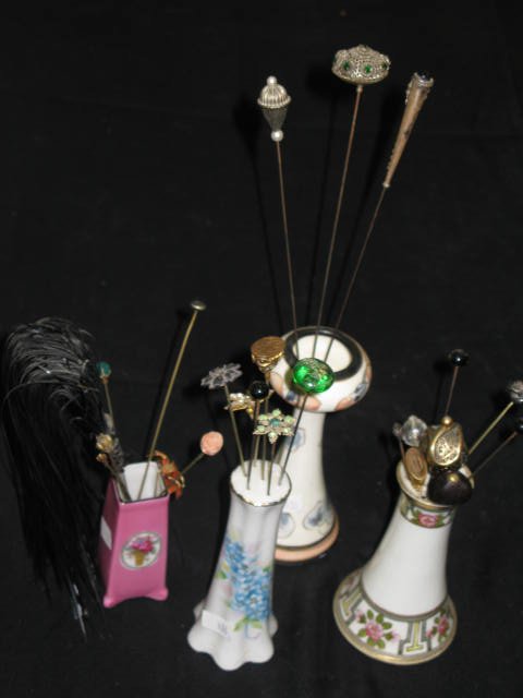 4 HATPIN HOLDERS W/VINTAGE HATPINS: 4 HATPIN HOLDERS W/VINTAGE HATPINS. ONE HATPIN HOLDER IS NIPPON. 1 IS MARKED CHEKOSLOVAKIA (PINK). ONE W/BLUE FLORAL DESIGN HAS NO STOPPER AT BASE.