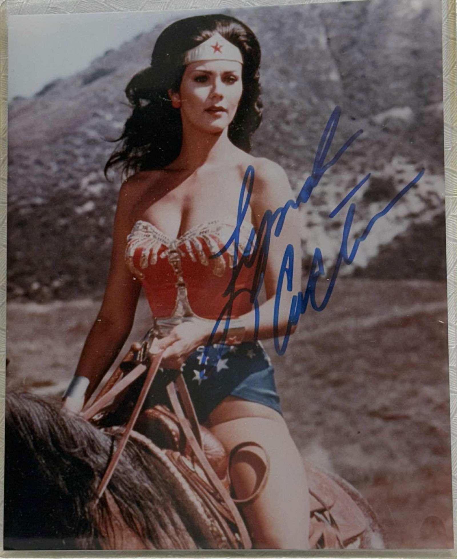 Lynda Carter Signed 8×10 Photo as Wonder Woman — COA: Original color 8×10 photograph of Lynda Carter as Wonder Woman from the classic 1970s television series, boldly autographed in blue marker across the image. Includes a Certificate of Authenticity fro