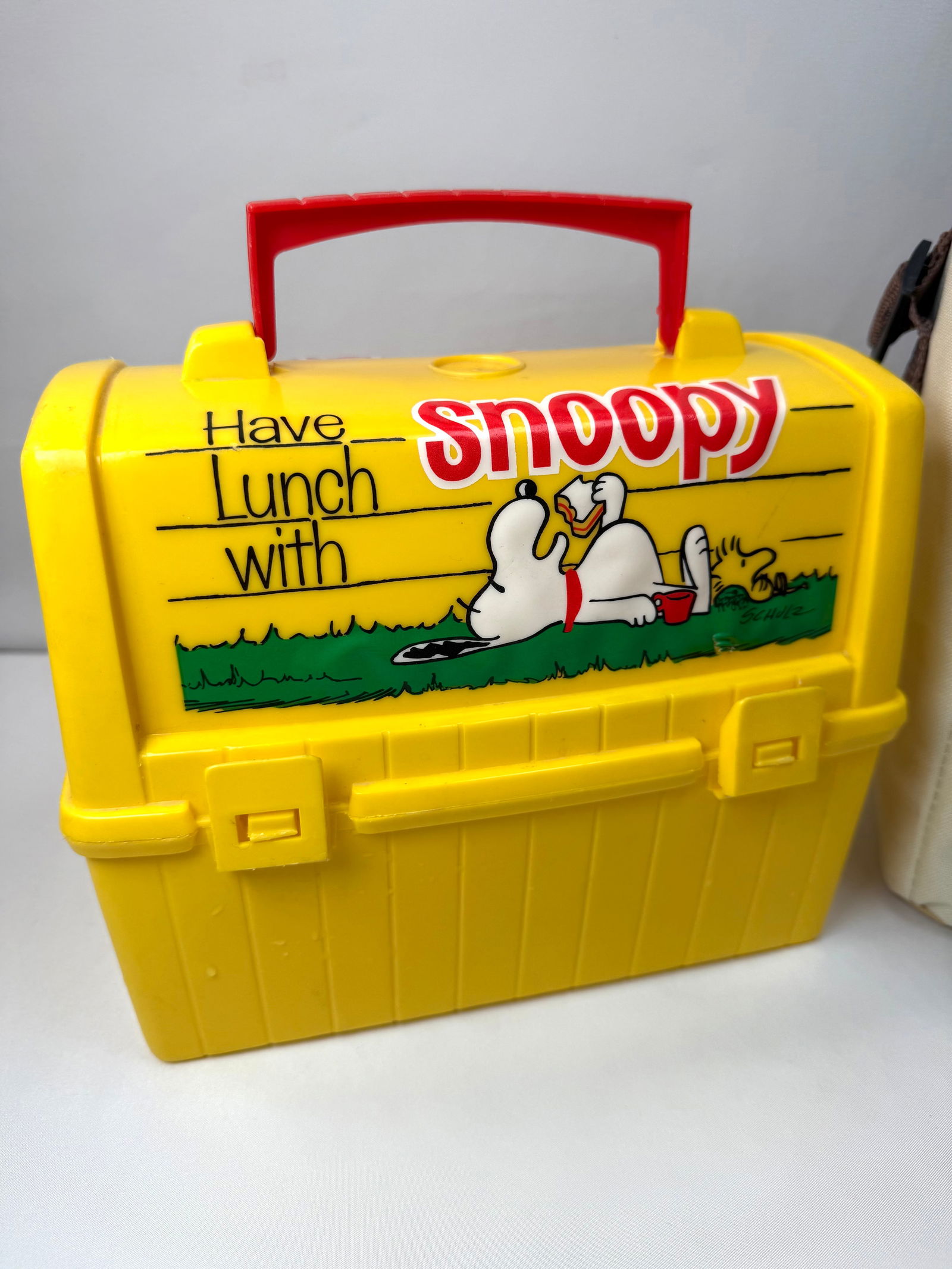1968 Snoopy “Have Lunch With Snoopy” Yellow Plastic Lunchbox – United Feature Syndicate: Offered here is an original 1968 Snoopy yellow plastic lunchbox, licensed by United Feature Syndicate and featuring classic Charles Schulz artwork of Snoopy relaxing with a book and picnic scene. This