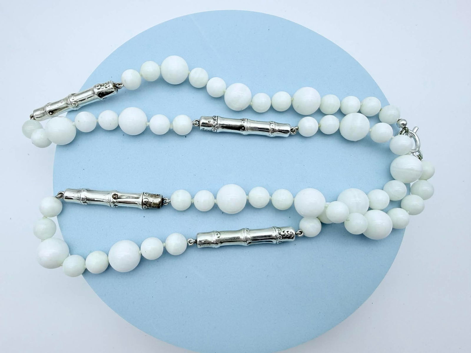 Sterling Silver & White Bead Necklace, Marked 925 Bamboo-Style Connectors: Elegant white beaded necklace featuring graduated spherical beads accented by two bamboo-form sterling silver connectors. The connectors are clearly stamped 925, and the toggle clasp appears to be mar