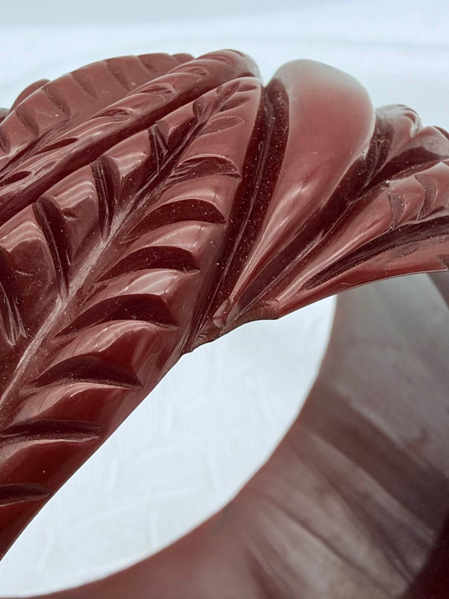 Vintage Catalin Bakelite Carved Bangle Bracelet, Cherry Red, c. 1940s–50s: Vintage carved Catalin Bakelite bangle bracelet, mid-20th century, likely produced by a New York studio. The bracelet features a deeply carved leaf and feather-style motif with strong dimensional reli