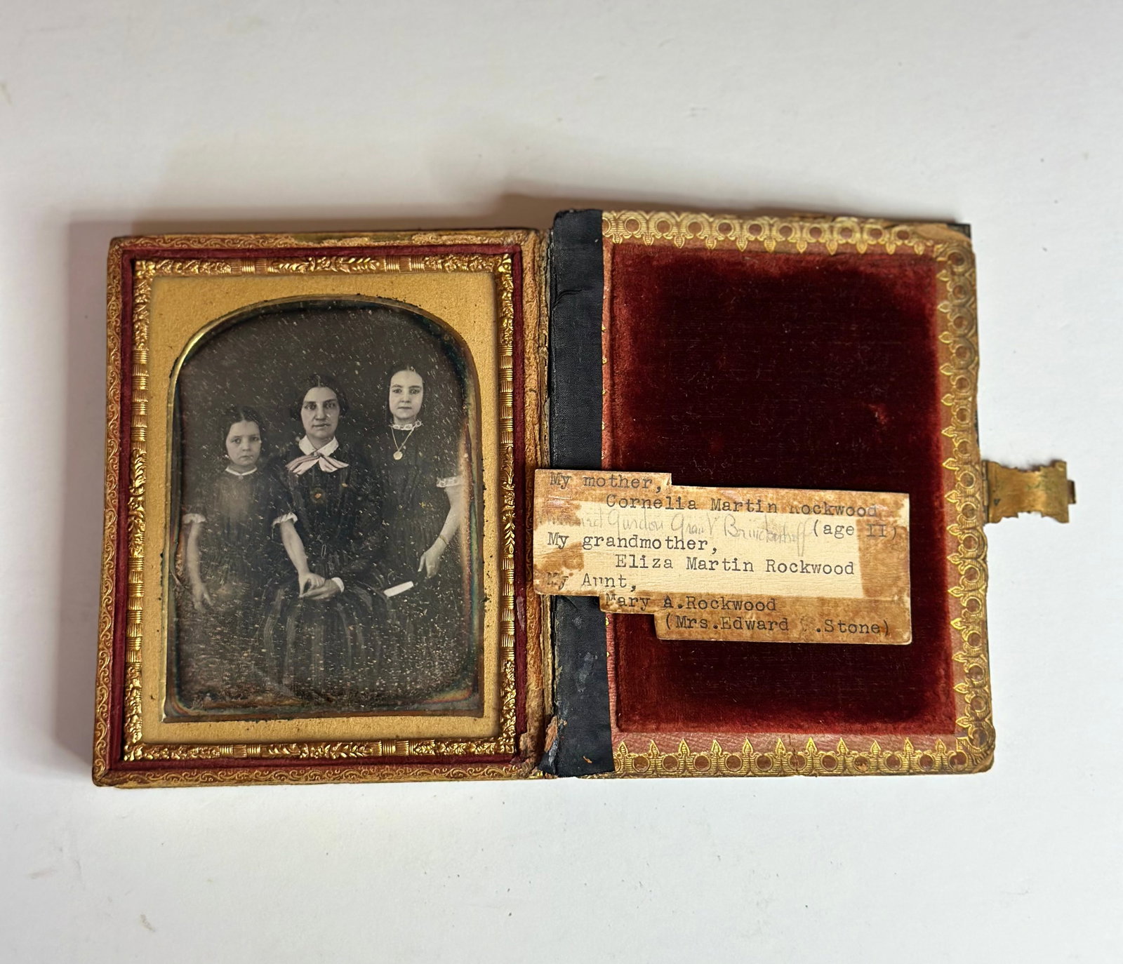 Antique Victorian Daguerreotype Family Portrait Identified Rockwood / Martin Family: Antique Victorian daguerreotype featuring a group portrait of three sitters, likely a mother and two daughters, presented behind a decorative brass mat. Accompanied by a period label identifying the s
