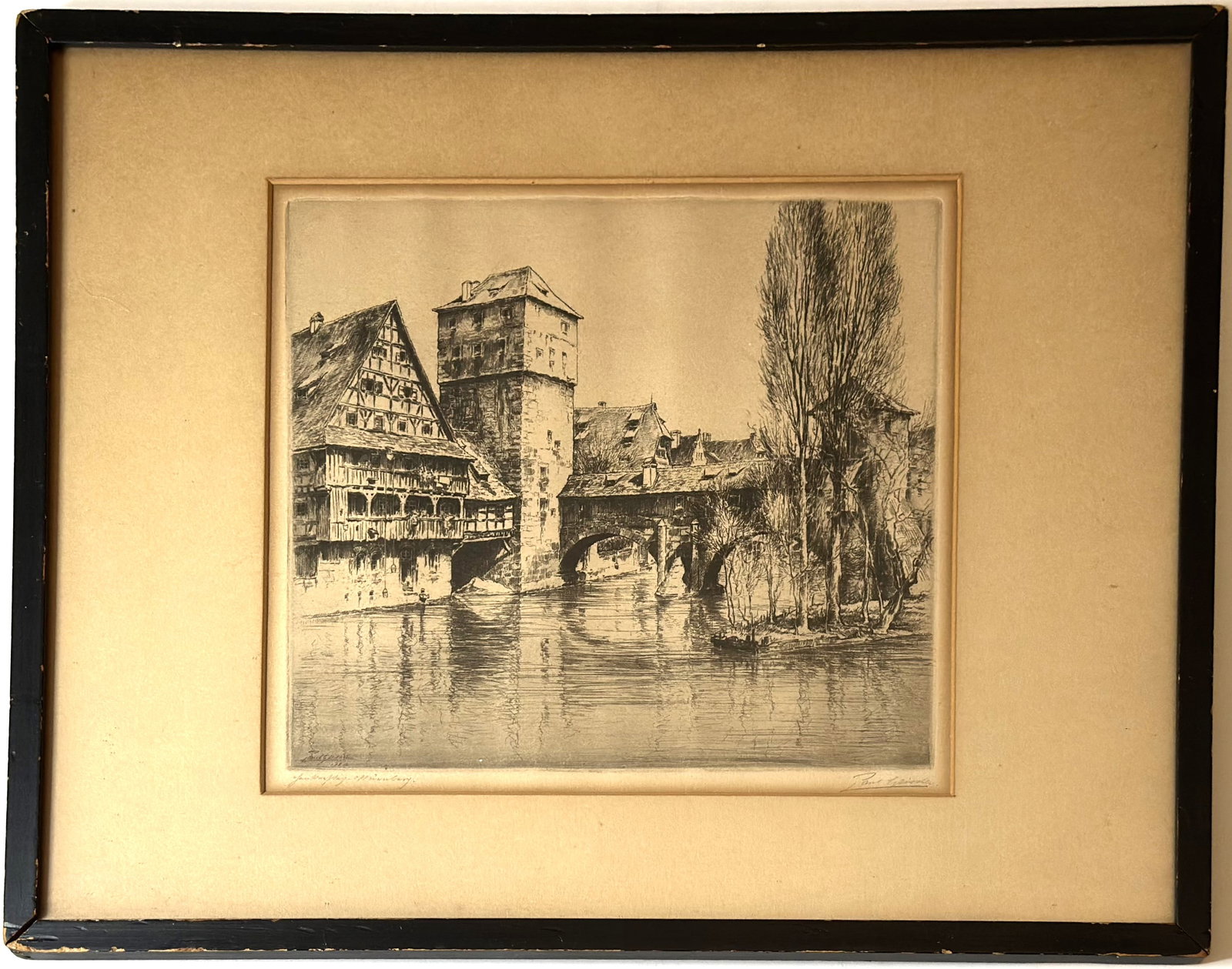Vintage European Architectural Etching Signed Pencil Framed River Scene: Vintage European architectural etching depicting a historic riverside scene with timber-frame buildings, a tower structure, and a stone bridge spanning the water. Executed in fine line work with stron
