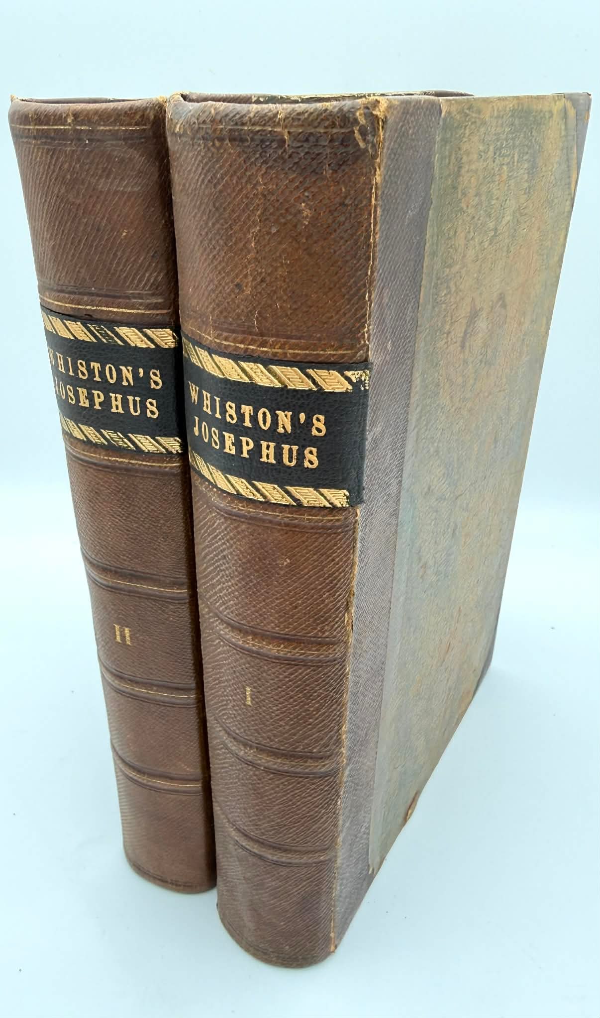Antique 2 Vol Set Works of Flavius Josephus Whiston Leather Bindings c.19th Century: Two-volume set of The Works of Flavius Josephus, translated by William Whiston, published by George Virtue, London. Octavo volumes bound in period half leather over marbled boards, with raised bands a