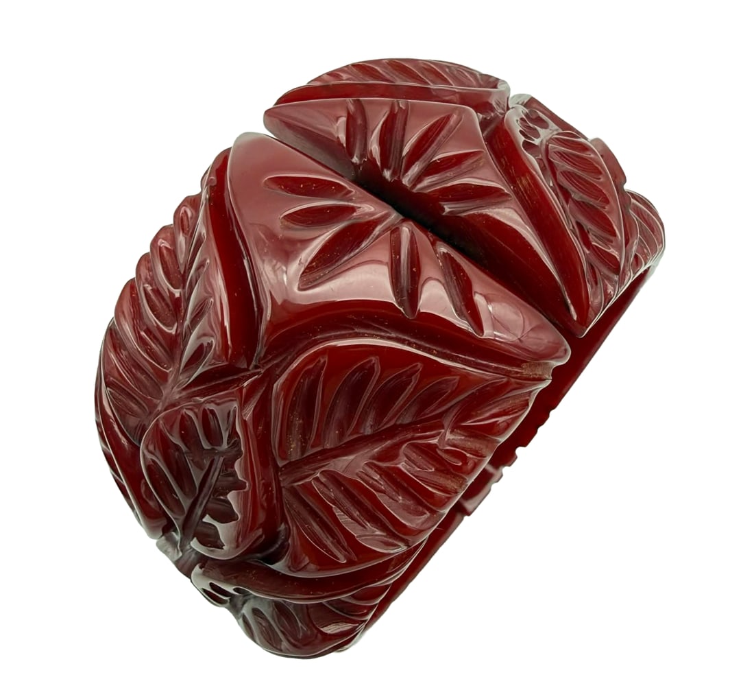 Vintage Carved Catalin (Bakelite) Hinged Cuff Bracelet – New York Studio, Warhol-Era Associated: A striking vintage Catalin (phenolic resin, commonly referred to as Bakelite) hinged cuff bracelet from a New York studio collection, featuring bold carved floral and foliate motifs in a rich cherry-r