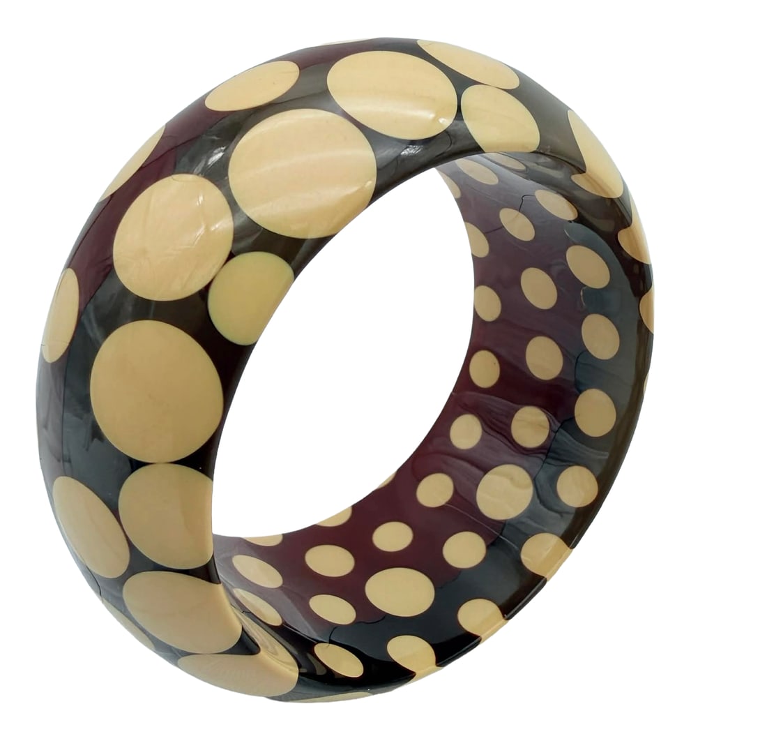 Vintage Polka Dot Bakelite Bangle Bracelet, Cream on Multicolor Ground, Mid-Century – New York: Vintage mid-century Bakelite bangle bracelet featuring a bold polka dot design with cream-colored circular inlays set against a multicolor ground of deep red, blue-grey, and translucent tones. The bra